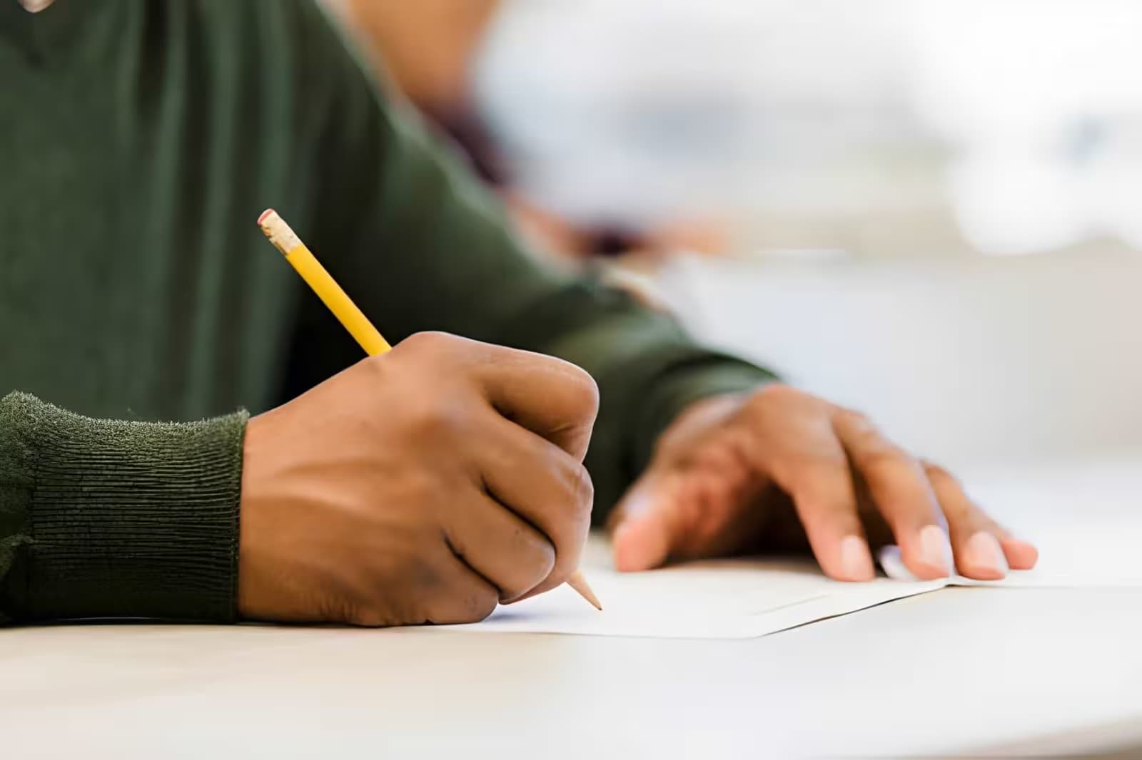 Student writing answers in a workbook